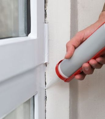 door waterproofing using caulking and a caulk gun