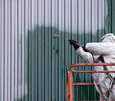 commercial painting contractors in broward county spraying a commercial building with green paint