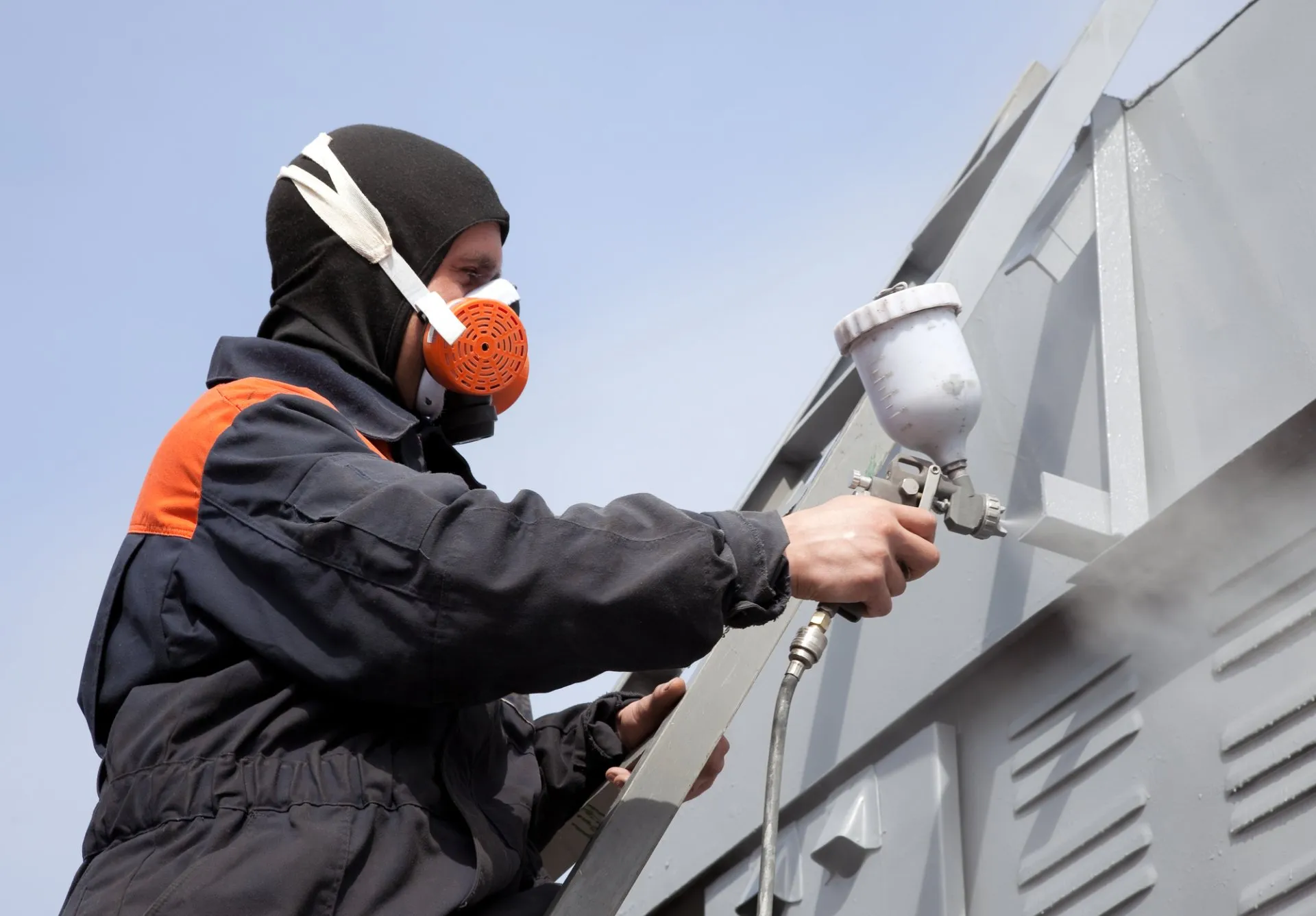 Commercial Painting contractor spraying a building with paint