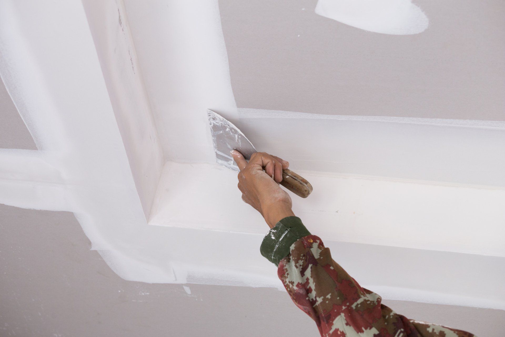 a putty knife is used to repair this drywall ceiling in Plantation FL