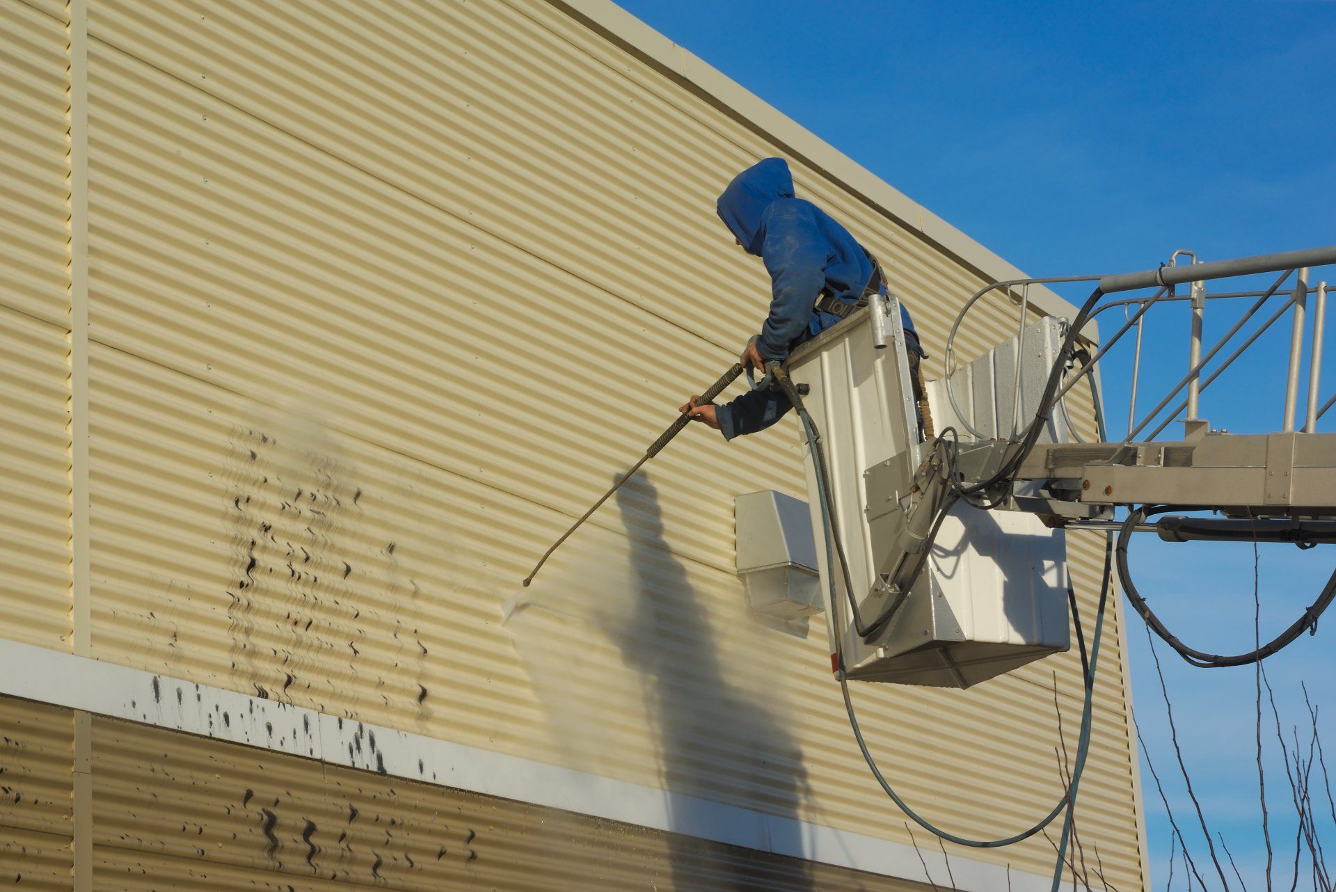 contractor from Fort Lauderdale Painters pressure washing the exterior of this warehouse in Coral Springs FL