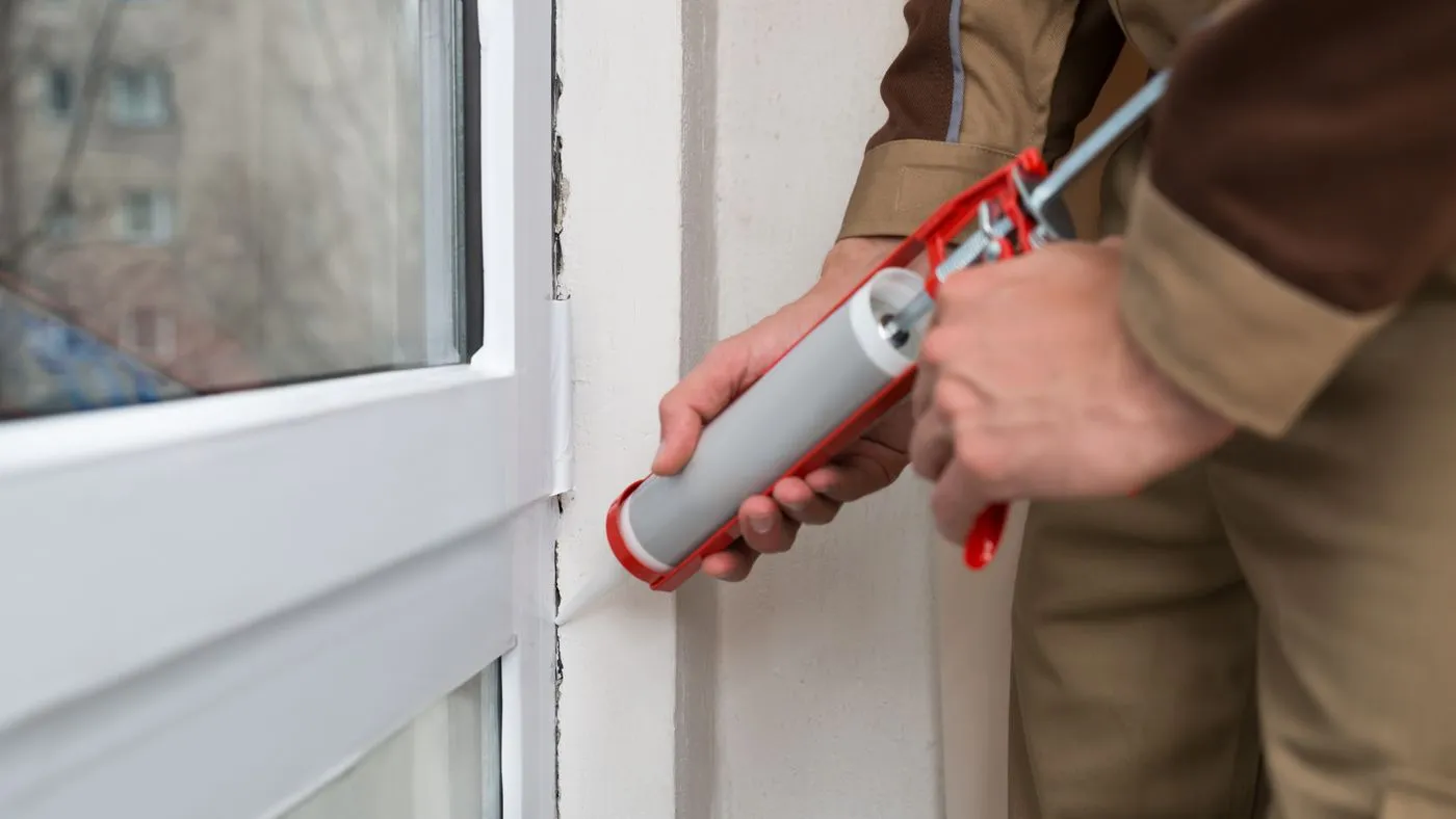 Man caulking to waterproof house in fort lauderdale